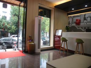 a store front with two stools in front of a window at Thank Inn Chain Hotel Jiangxi Ganzhou Quannan County Shoumei Road in Quannan