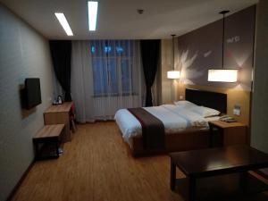 a large hotel room with a bed and a table at Thank Inn Chain Hotel Qinghai Yushu County Kangba Commercial City in Yushu