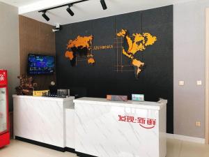 a lobby with a counter with a map on the wall at JUN Hotels Shandong Binzhou Boxing County Bus Station in Binzhou
