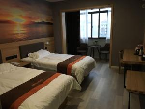 a hotel room with two beds and a window at JUN Hotels Anhui Fuyang Yingshang County Guanzhong Avenue Store in Fuyang