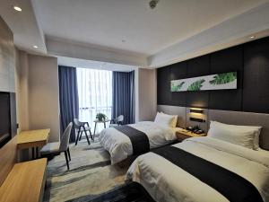 カン州市にあるUp And In Ganzhou Zhanggong District Baoneng Cityのベッド2台とデスクが備わるホテルルームです。