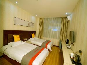 pokój hotelowy z 2 łóżkami i telewizorem w obiekcie JUN Hotels Gansu Jiayuguan Jingtie District Guanghui Community w mieście Jiayuguan