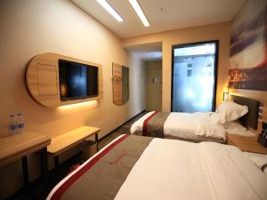 a hotel room with two beds and a flat screen tv at Thank Inn Chain Hotel Anhui Bengbu Huaiyuan County Huarun Suguo Store in Wuchazhen