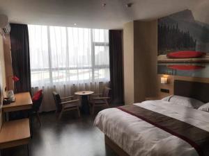 ein Hotelzimmer mit einem Bett und einem Tisch und Stühlen in der Unterkunft Thank Inn Chain Hotel Guangdong Dongguan Daling Mountain Guanchang Road in Dongguan