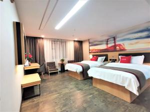 um quarto de hotel com duas camas e uma secretária em Thank Inn Chain Hotel Guangan Huaying Phoenix City em Shuang-ho