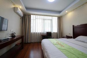 a hotel room with a large bed and a window at JUN Hotels Guangdong Shenzhen Yantian District Zhongying Street in Shenzhen