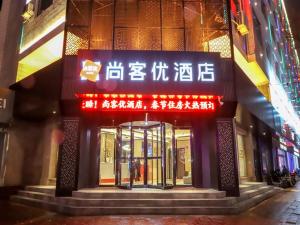 un edificio con letreros en la parte delantera en Thank Inn Chain Hotel Shanxi Yuncheng Ruicheng County Dongmao Plaza Store, en Yuncheng