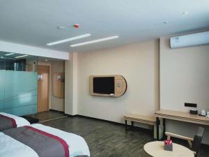 a hotel room with a bed and a tv on the wall at Thank Inn Chain Hotel Jiangmen Kaiping Shuikou Passenger Transport Station in Jiangmen