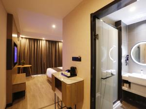 a hotel room with a bathroom with a sink and a shower at Up and In Kashgar Xiyu Avenue Food Street in Kashgar +11 photos