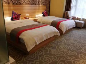 una habitación de hotel con 2 camas en una habitación en JUN Hotels Sichuan Chengdu Jianyang Jiancheng Town Jianshe Road, en Jianyang
