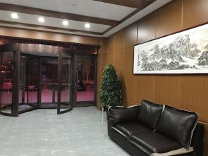 a lobby with a leather couch and a picture on the wall at Thank Inn Chain Hotel Shandong Laiwu Laicheng District Changshou North Road People's Hospital in Laiwu