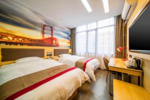 a hotel room with two beds and a flat screen tv at Thank Inn Plus Hotel Guizhou Zunyi Old Railway Station in Zunyi