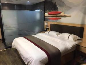 ein Schlafzimmer mit einem großen Bett in einem Zimmer in der Unterkunft Thank Inn Chain Hotel Guangdong Dongguan Daling Mountain Guanchang Road in Dongguan