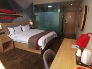 a hotel room with a bed and a chair at Thank Inn Chain Hotel Qinghai Haixi Wulan Xinghai Business Street in Kaiba