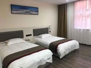 a hotel room with two beds and a window at Thank Inn Chain Hotel Shandong Laiwu Laicheng District Changshou North Road People's Hospital in Laiwu