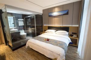 a bedroom with a large bed and a bathroom at Thank Inn Chain Hotel Ganzhou Zhanggong District Wanxiang City in Ganzhou