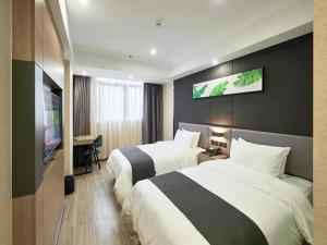 a hotel room with two beds and a flat screen tv at Up And In Hubei Xianning Tongshan County Building Material Market in Xianning