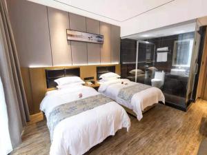 a hotel room with two beds and a bathroom at Thank Inn Chain Hotel Ganzhou Zhanggong District Wanxiang City in Ganzhou
