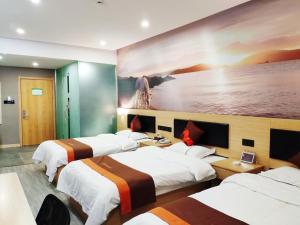 a hotel room with four beds and a painting on the wall at JUN Hotels Hebei Xingtai Qinghe County Bohai Road in Huangjinzhuang