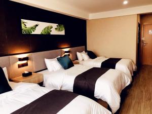 una habitación de hotel con 3 camas y aversión en Up And In Kashgar Shache County Buxing Street, en Shache