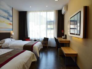 a hotel room with two beds and a desk at Thank Inn Chain Hotel Guizhou Tongren Bijiang District High-speed Railway Station Qingshui Avenue Store in Tongren