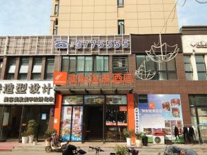 a building with a sign on the front of it at JUN Hotels Anhui Suzhou Lingbi County Riyue Star City Laidi Shopping Street Store in Suzhou