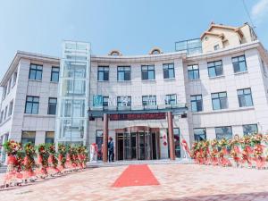 een man staat voor een gebouw bij Up And In Qingdao Jimo District Aoshanwei Blue Silicon Valley in Qingdao