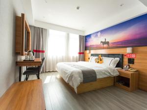 a hotel room with a bed and a painting on the wall at JUN Hotels Hubei Xianning Tongshan County Jiugong Avenue in Xianning