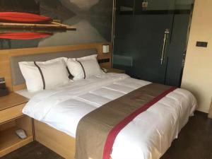 Кровать или кровати в номере Thank Inn Chain Hotel Qinghai Haixi Wulan Xinghai Business Street