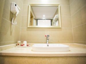 a bathroom sink with a mirror and a phone at Thank Inn Plus Hotel Yichang Free Trade Zone Development Avenue in Yichang
