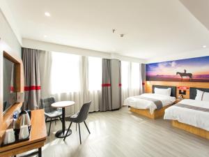 a hotel room with two beds and a desk and a table at JUN Hotels Hubei Xianning Tongshan County Jiugong Avenue in Xianning