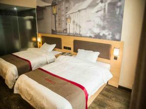 2 Betten in einem Hotelzimmer mit 2 in der Unterkunft Thank Inn Chain Hotel Guizhou Guiyang Guanshanhu District Century City Store in Guiyang
