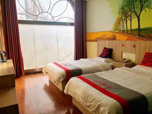 ein Hotelzimmer mit 2 Betten und einem Fenster in der Unterkunft JUN Hotels Hebei Hengshui Taocheng District Renmin Road Changming Avenue in Hengshui