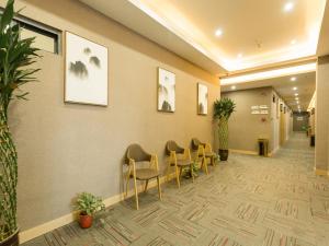 einen Wartebereich in einem Krankenhaus mit Stühlen und Pflanzen in der Unterkunft Thank Inn Chain Hotel Xi'an Weiyang District High Speed Rail North Passenger Station in Xi'an