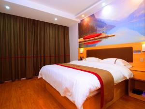 a bedroom with a large bed with a painting on the wall at Thank Inn Chain Hotel Jiangxi Fuzhou Dongxiang District High Speed ââRailway Station in Fuzhou