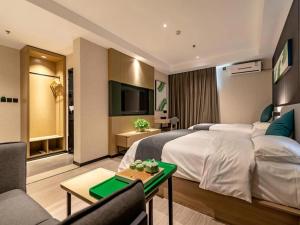 Habitación de hotel con cama grande y sofá en Up And In Henan Anyang Hongqi Road Wal-Mart en Anyang
