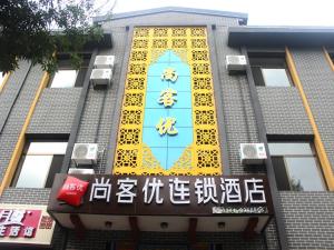 un bâtiment avec un panneau bleu et jaune dans l'établissement Thank Inn Chain Hotel Hebei Chengde Shuangqiao District Chenghuangmiao, à Chengde
