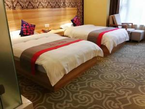 a hotel room with two beds and a couch at JUN Hotels Sichuan Chengdu Jianyang Jiancheng Town Jianshe Road in Jianyang