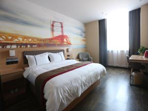 a hotel room with a large bed and a painting at Thank Inn Plus Hotel Shijiazhuang Gaocheng District Century Avenue in Shijiazhuang