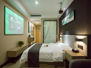 a hotel room with a large bed and a projection screen at Up and In Shanxi Taiyuan Zonggai Shifanqu in Taiyuan