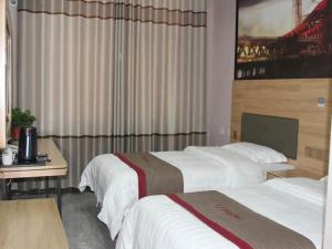 a hotel room with two beds and a desk at Thank Inn Chain Hotel Shandong Linyi Linshu County Cangshan South Road in Linyi