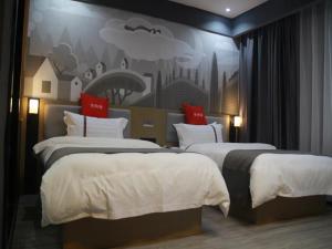 a hotel room with two beds and a painting on the wall at Thank Inn Chain Hotel Jiangxi Ganzhou Quannan County Shoumei Road in Quannan