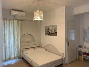ein kleines Schlafzimmer mit einem Bett und einem Kronleuchter in der Unterkunft Noufaro in Mylopotas