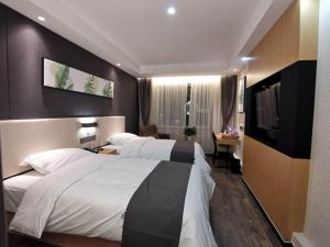 a hotel room with two beds and a flat screen tv at Thank Inn Chain Hotel Shandong Linyi Junan County Longshan Road in Linyi