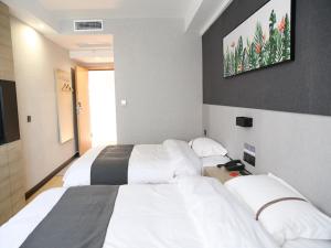 a hotel room with two beds and a television at Thank Inn Chain Hotel Shanxi Jinzhong Yuci District Yunhua Street in Jinzhong
