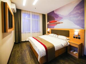 a hotel room with a bed and a painting on the wall at Thank Inn Chain Hotel Panjin Shuangtaizi District Railway Station in Panjin