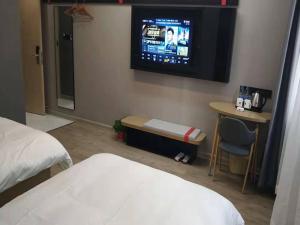 a hotel room with a bed and a tv on the wall at Thank Inn Chain Hotel Anhui Suzhou Lingbi County People's Hospital Zhongxiu Jincheng in Suzhou