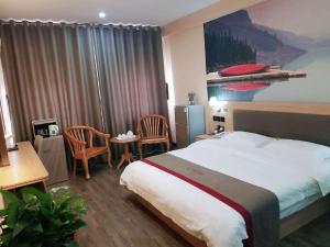 ein Hotelzimmer mit einem Bett und einem Tisch und Stühlen in der Unterkunft Thank Inn Chain Hotel Shandong Dezhou Lingcheng District Lingzhou Road Ginza in Dezhou + 8 Fotos