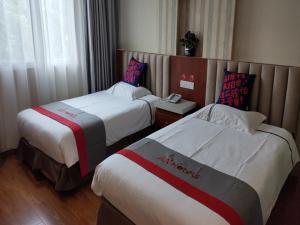 ein Hotelzimmer mit 2 Betten und einem Telefon in der Unterkunft JUN Hotels Shanghai Chongming Xuegong Road Meizhou Road in Shanghai
