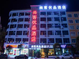 un bâtiment avec un panneau rouge devant lui dans l'établissement Up And In Guizhou Qian Southwest Xingyi City Mengle City, à Xiawutun